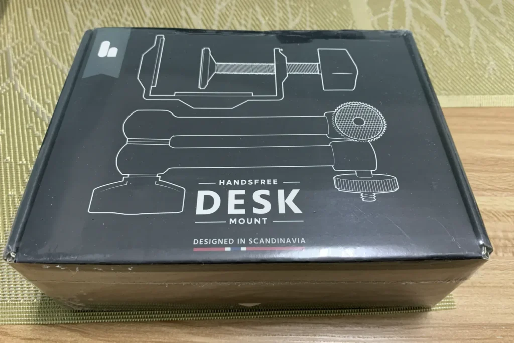 Verpackung des Handsfree Desk Mount Kit für The Handy mit Abbildung der Tischhalterung.