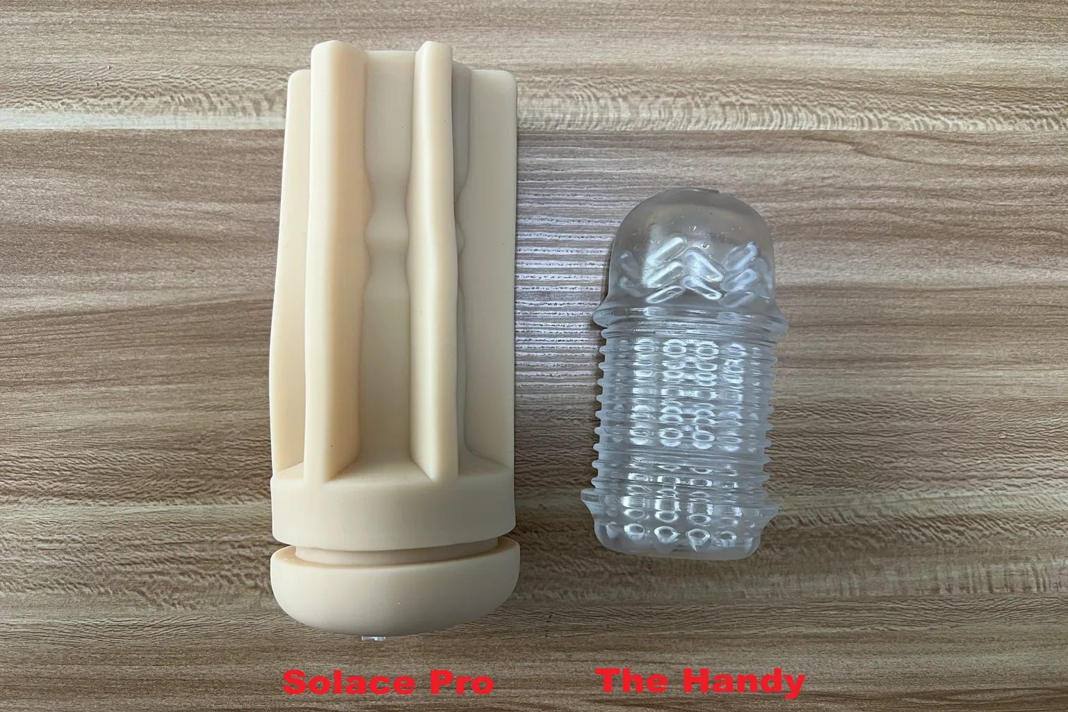 Vergleich der beigen TPE-Hülse des Lovense Solace Pro mit der transparenten Hülse von The Handy, um Unterschiede bei Länge, Größe und Form zu zeigen